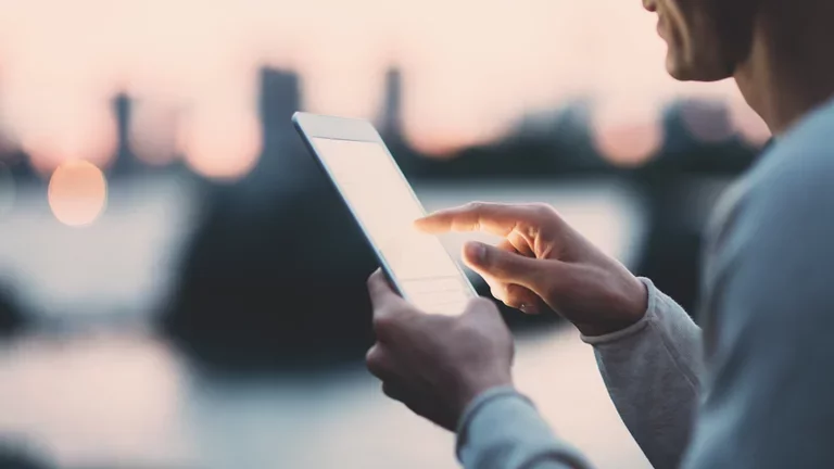 Young man texting on a tablet